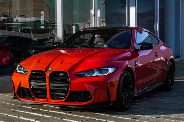 red bmw m 3 coupe parked on gray concrete pavement during daytime