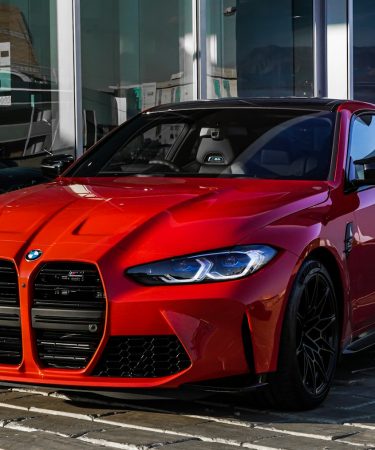 red bmw m 3 coupe parked on gray concrete pavement during daytime